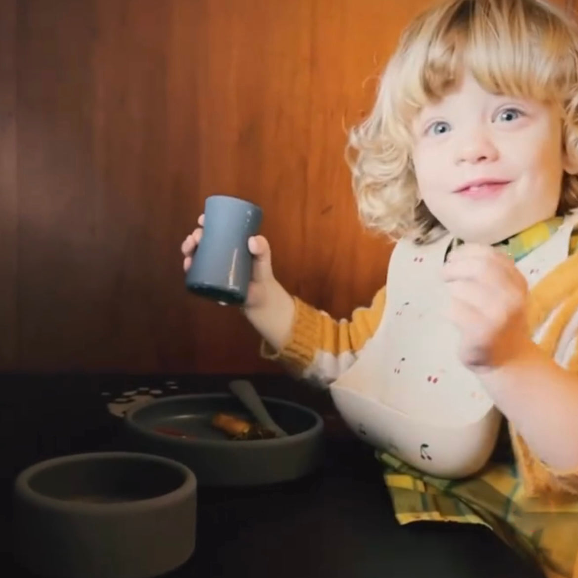 a happy toddler using blue hour aplainr mealtime set